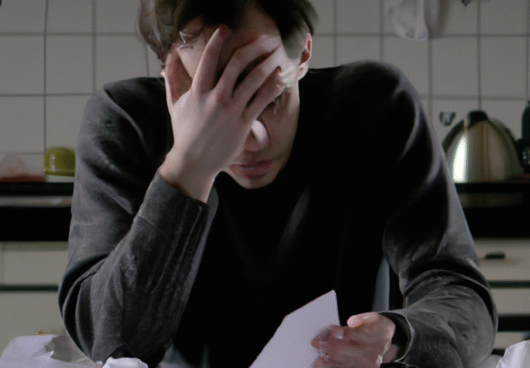 A person looking conflicted, sitting alone at a kitchen table, head in hands, with scattered papers representing financial stress, dim lighting, thoughtful mood, realistic, cinematic atmosphere, 8k quality, photorealistic